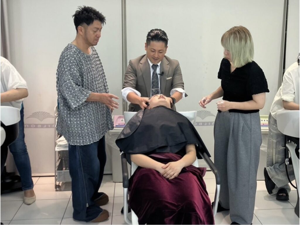 ミルボン大阪支店の美容師向けヘッドスパ講習で側頭部と側頭筋の技術を実演する久保鉄平