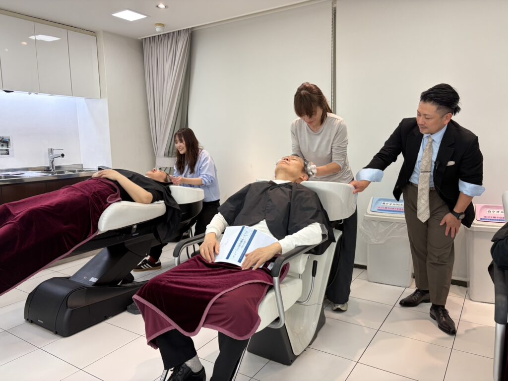 相モデルでヘッドスパを実践する受講者と、そばで指導する久保鉄平