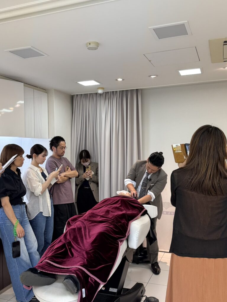 Airy Spa実践セミナーDAY1で、受講者の前でウェットヘッドスパを実演する久保鉄平